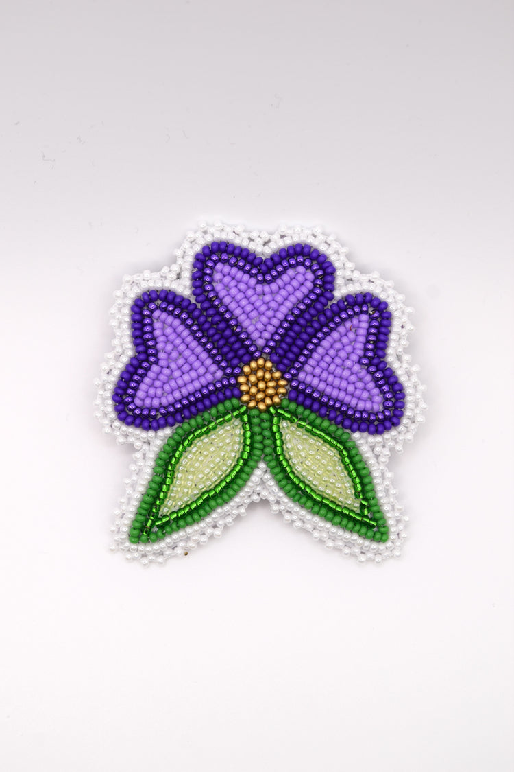 Broche perlée en forme de fleur violette aux feuilles vertes